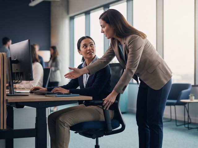 Especialista ajustando a postura de um trabalhador no posto de trabalho